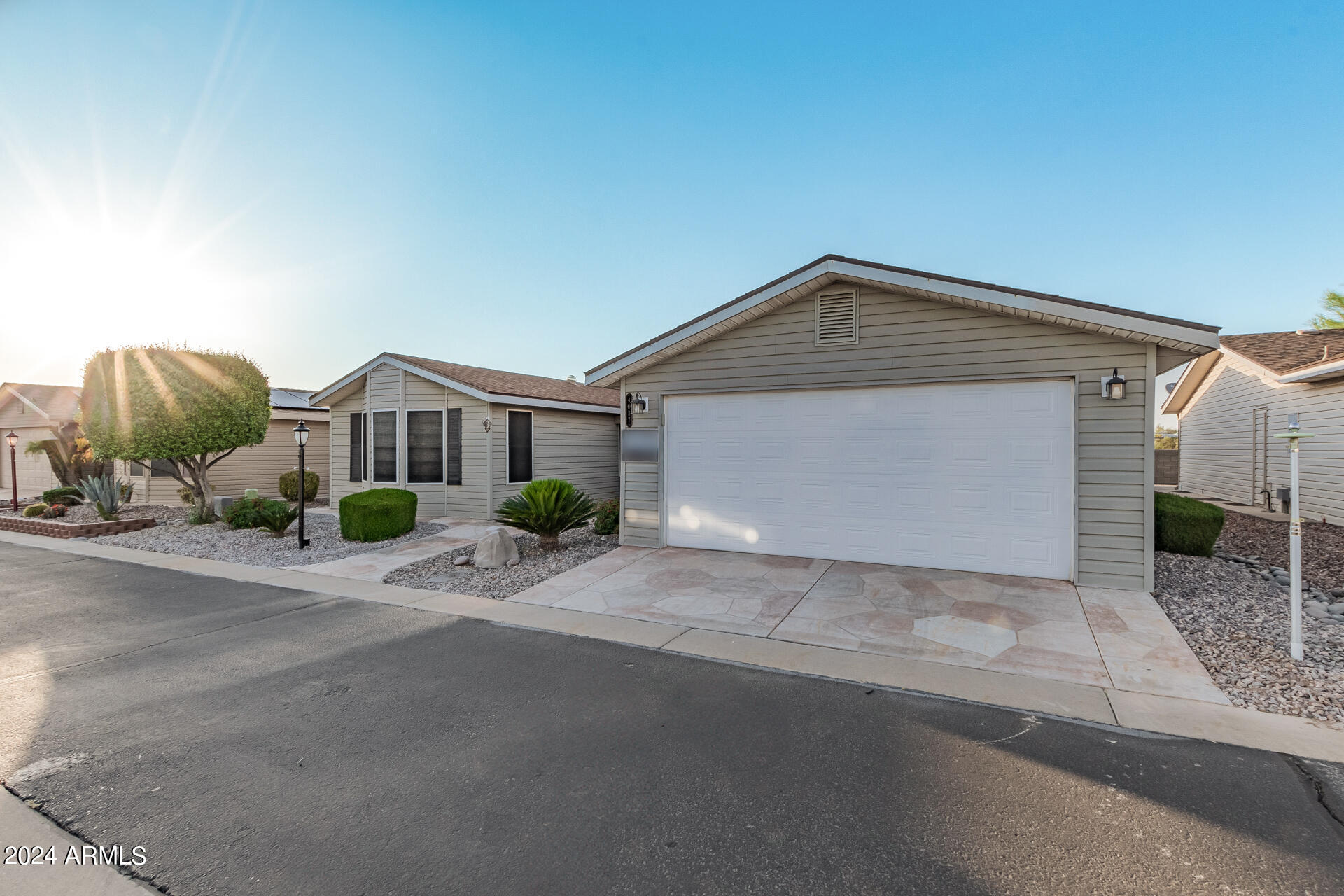 3301 South Goldfield Road, Unit 4037 Apache Junction, AZ 85119 - Photo 3 of 36 a front view of a house with a yard and garage
