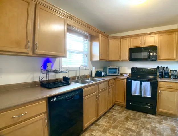 a kitchen with stainless steel appliances granite countertop a sink stove and cabinets