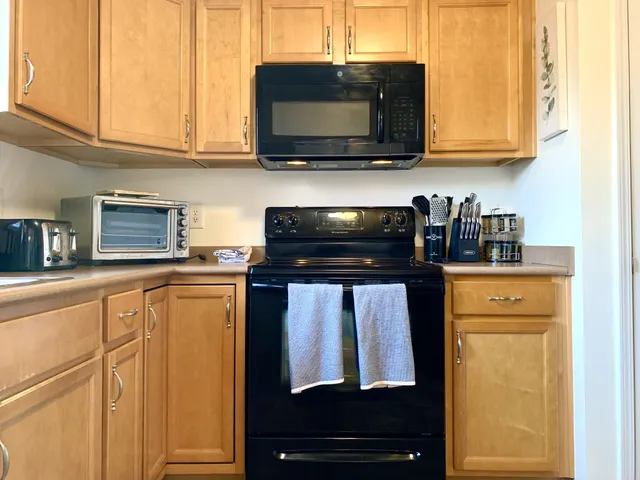 a kitchen with stainless steel appliances granite countertop white cabinets and black appliances