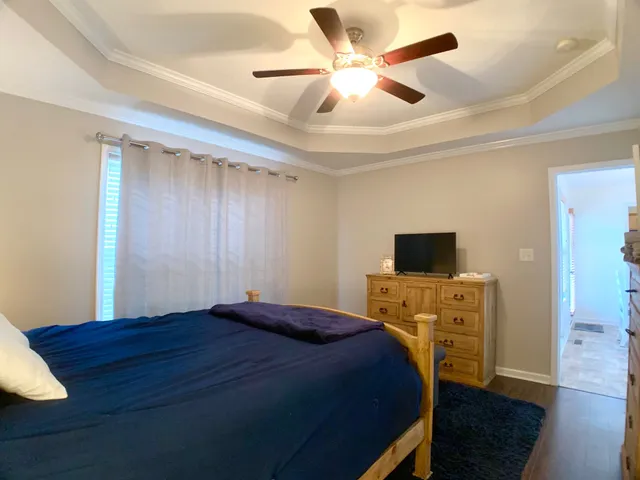 a bedroom with a bed and a flat tv screen on dresser