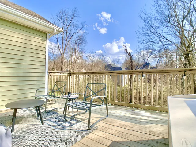 a view of a balcony with chairs and wooden floor