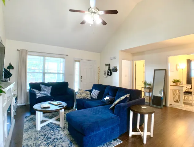 a living room with furniture and a wooden floor