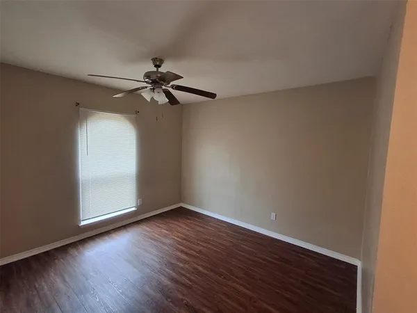 a view of a room with wooden floor and a ceiling fan