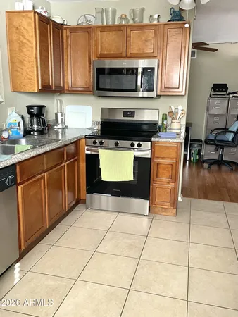 a kitchen with stainless steel appliances granite countertop a stove a sink a microwave and a refrigerator