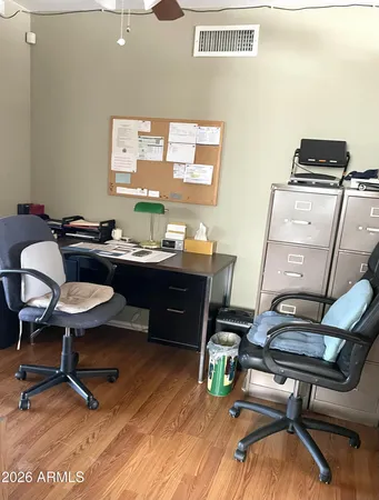 a view of a workspace with furniture and a window