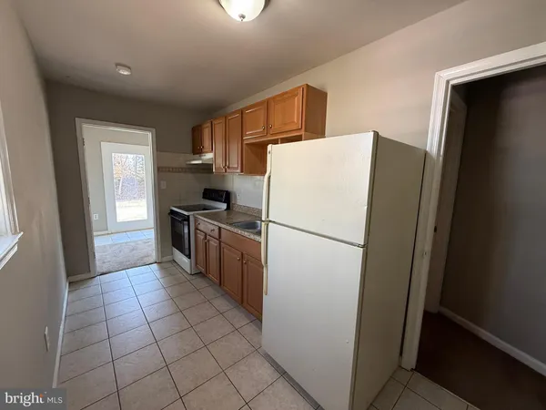 a kitchen with a refrigerator a stove top oven and cabinets