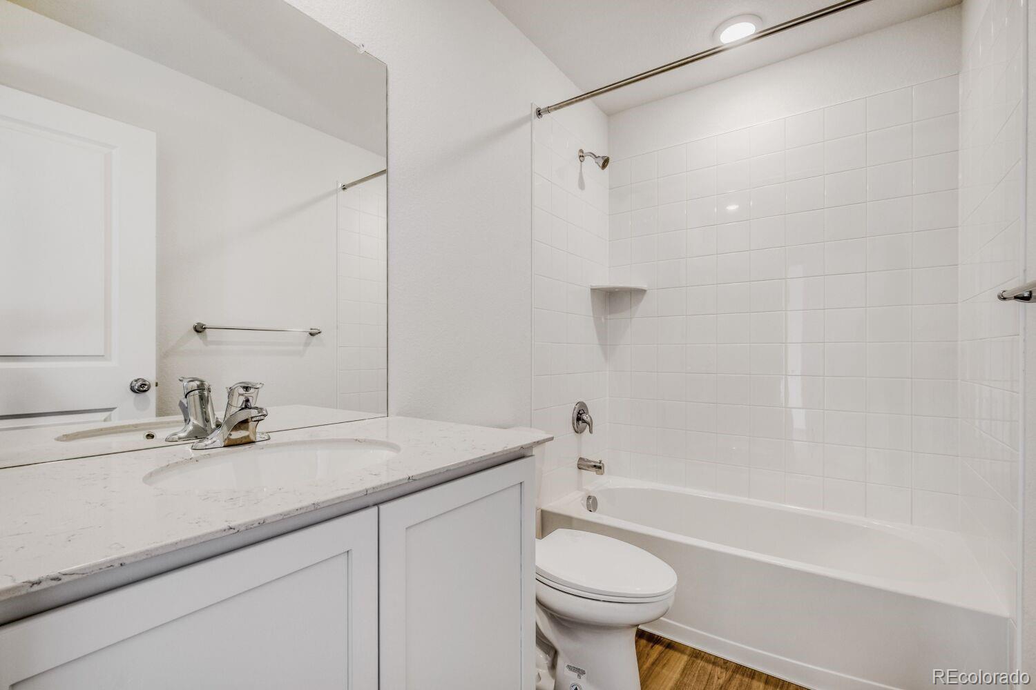 8922 Blue Feather Loop Colorado Springs, CO 80908 - Photo 15 of 18 a bathroom with a sink toilet a mirror and shower