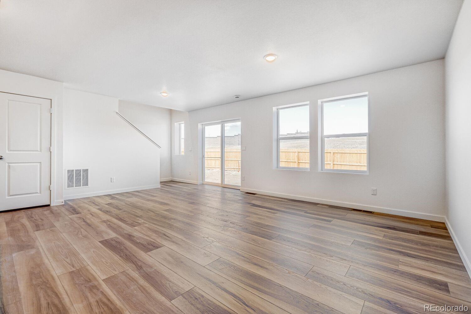 8922 Blue Feather Loop Colorado Springs, CO 80908 - Photo 7 of 18 a view of an empty room with wooden floor and a window