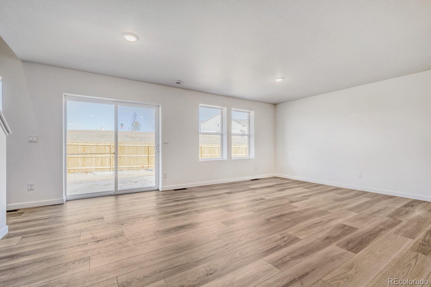 8922 Blue Feather Loop Colorado Springs, CO 80908 - Photo 8 of 18 an empty room with wooden floor and windows