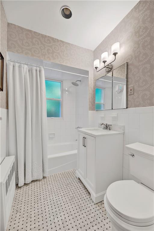 7607 Colonial Road Brooklyn, NY 11209 - Photo 23 of 35 a bathroom with a sink a toilet a mirror a vanity and bathtub
