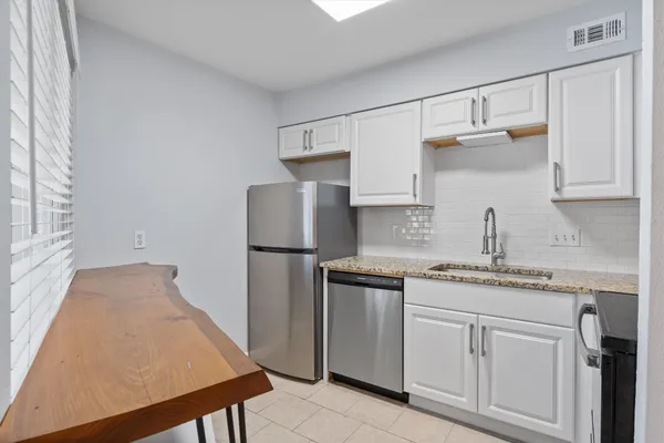a kitchen with refrigerator and cabinets