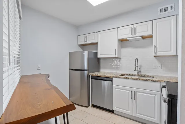 a kitchen with refrigerator and cabinets