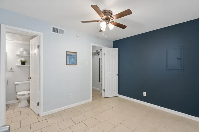 wooden floor in an empty room with a bathroom