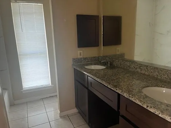 a bathroom with a granite countertop sink and a mirror