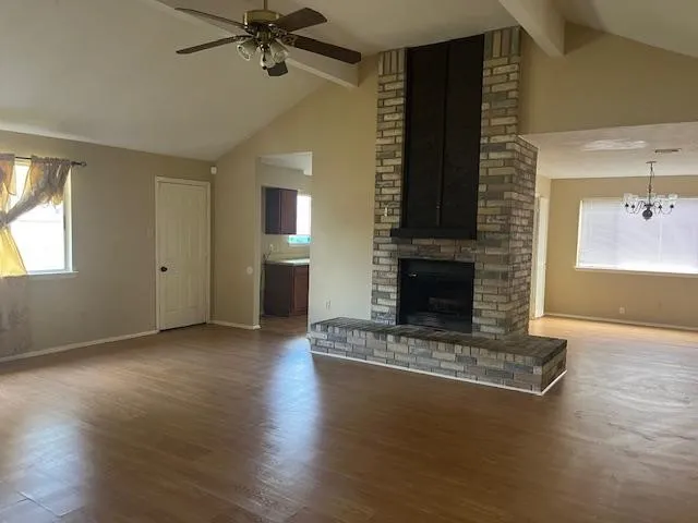 an empty room with windows and a fireplace