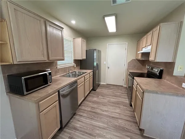 a kitchen with a sink stove and refrigerator