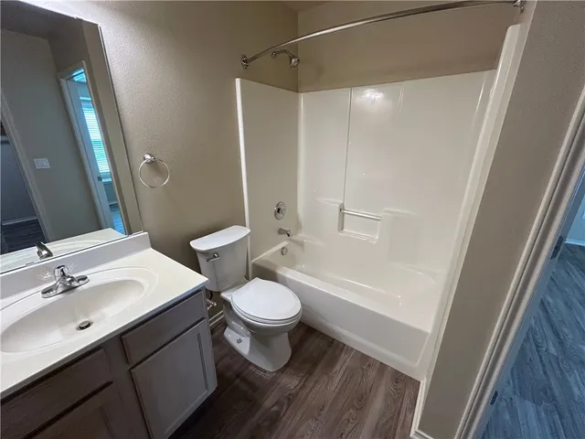 a bathroom with a sink a toilet a mirror and shower