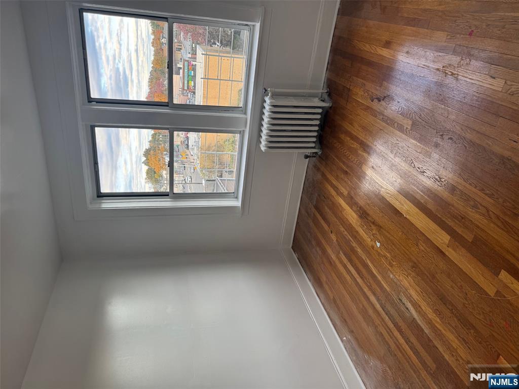 311 Queen Anne Road, Unit 46 Teaneck, NJ 07666 - Photo 5 of 6 a view of an empty room with wooden floor and a window