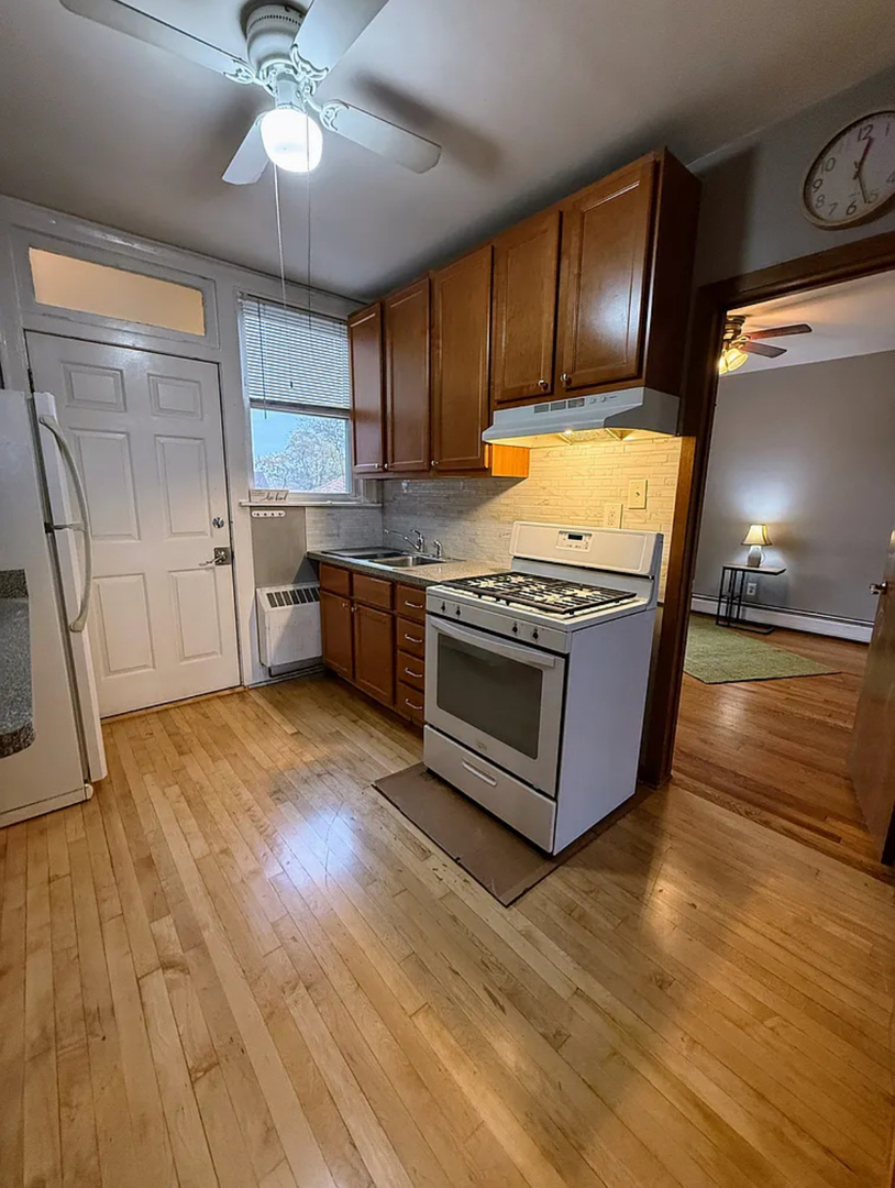 6010 West Seminole Street, Unit 2 Chicago, IL 60646 - Photo 3 of 14 a kitchen with stainless steel appliances granite countertop a stove a sink and a refrigerator