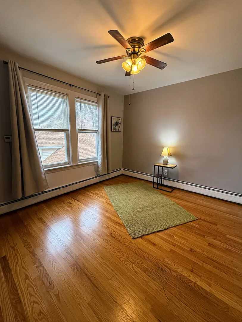 6010 West Seminole Street, Unit 2 Chicago, IL 60646 - Photo 5 of 14 a view of empty room with wooden floor and fan