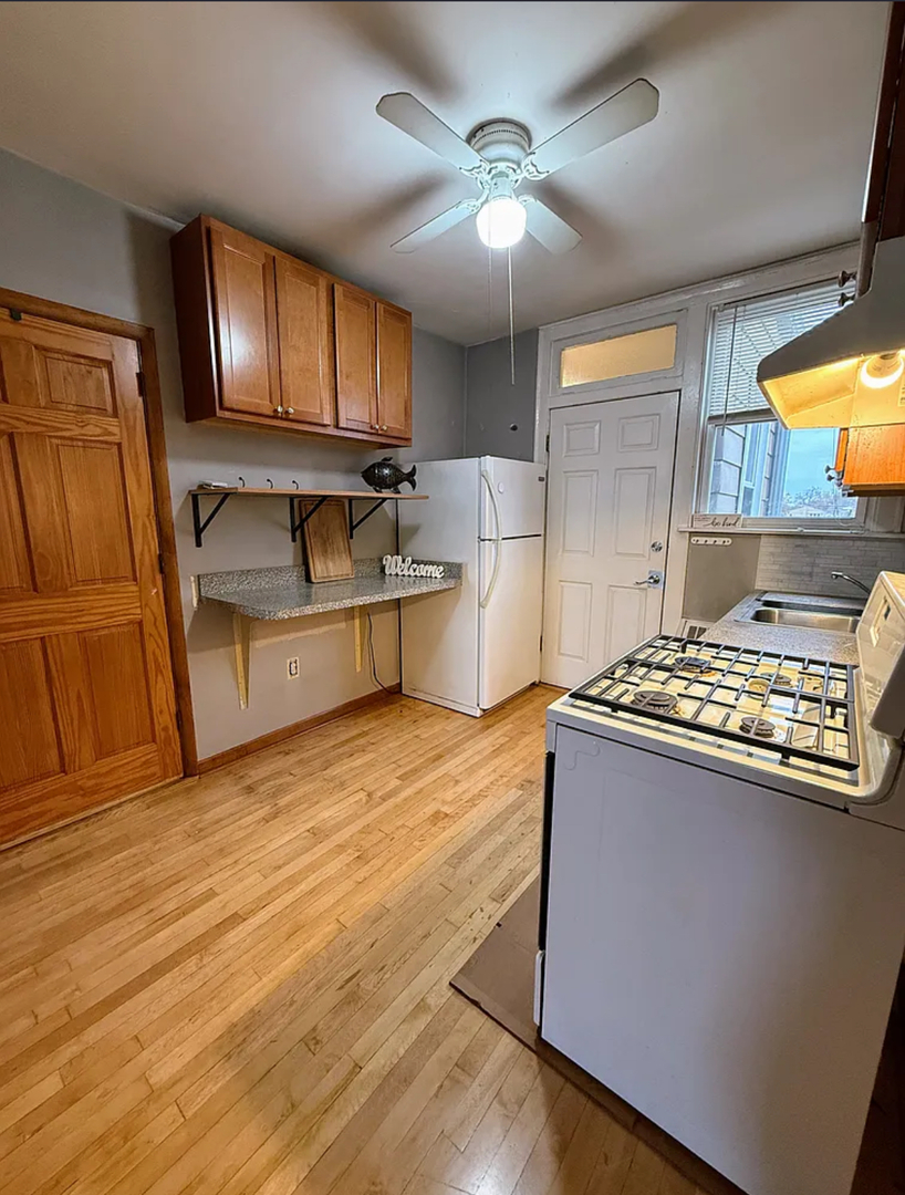 6010 West Seminole Street, Unit 2 Chicago, IL 60646 - Photo 8 of 14 a kitchen with stainless steel appliances granite countertop a sink stove and refrigerator