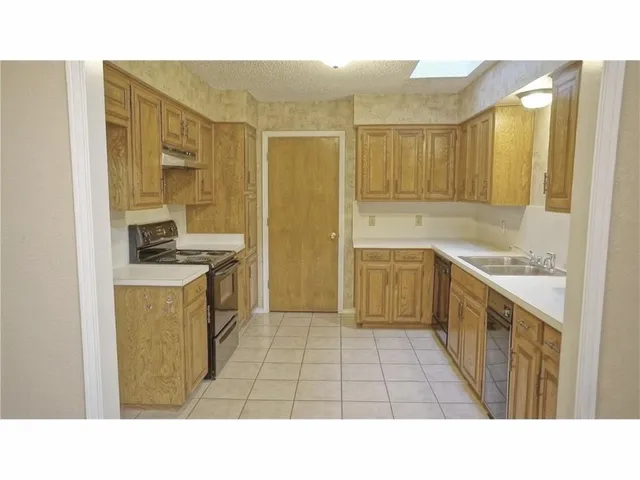 a open kitchen with a sink refrigerator and cabinets