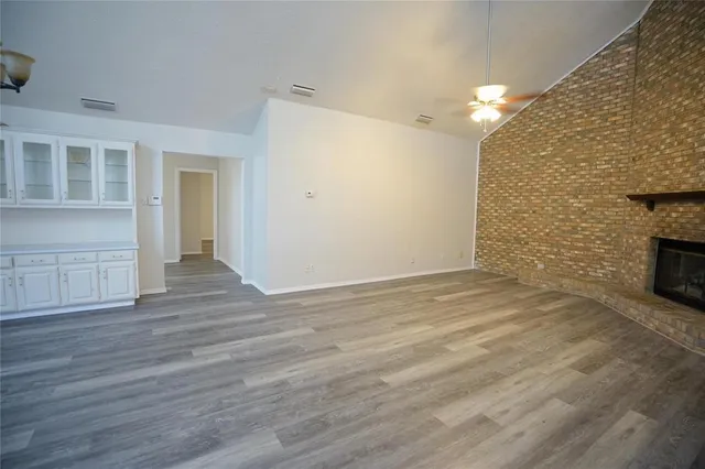 a view of empty room with wooden floor and fireplace