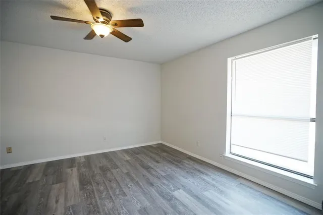 an empty room with a window and a fan