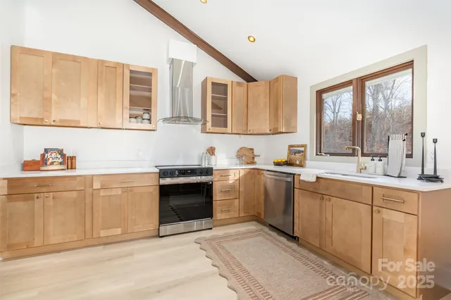 a kitchen with granite countertop a sink stainless steel appliances and cabinets