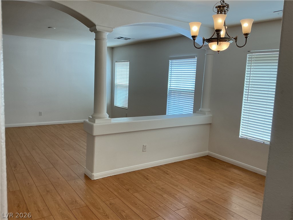 10975 Calcedonian Street Las Vegas, NV 89141 - Photo 5 of 25 This bright space features a classic chandelier and durable wood flooring.