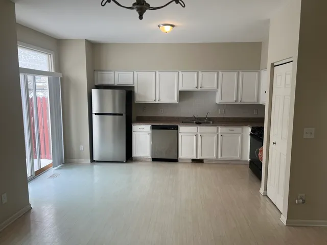 a kitchen with a sink a refrigerator and cabinets