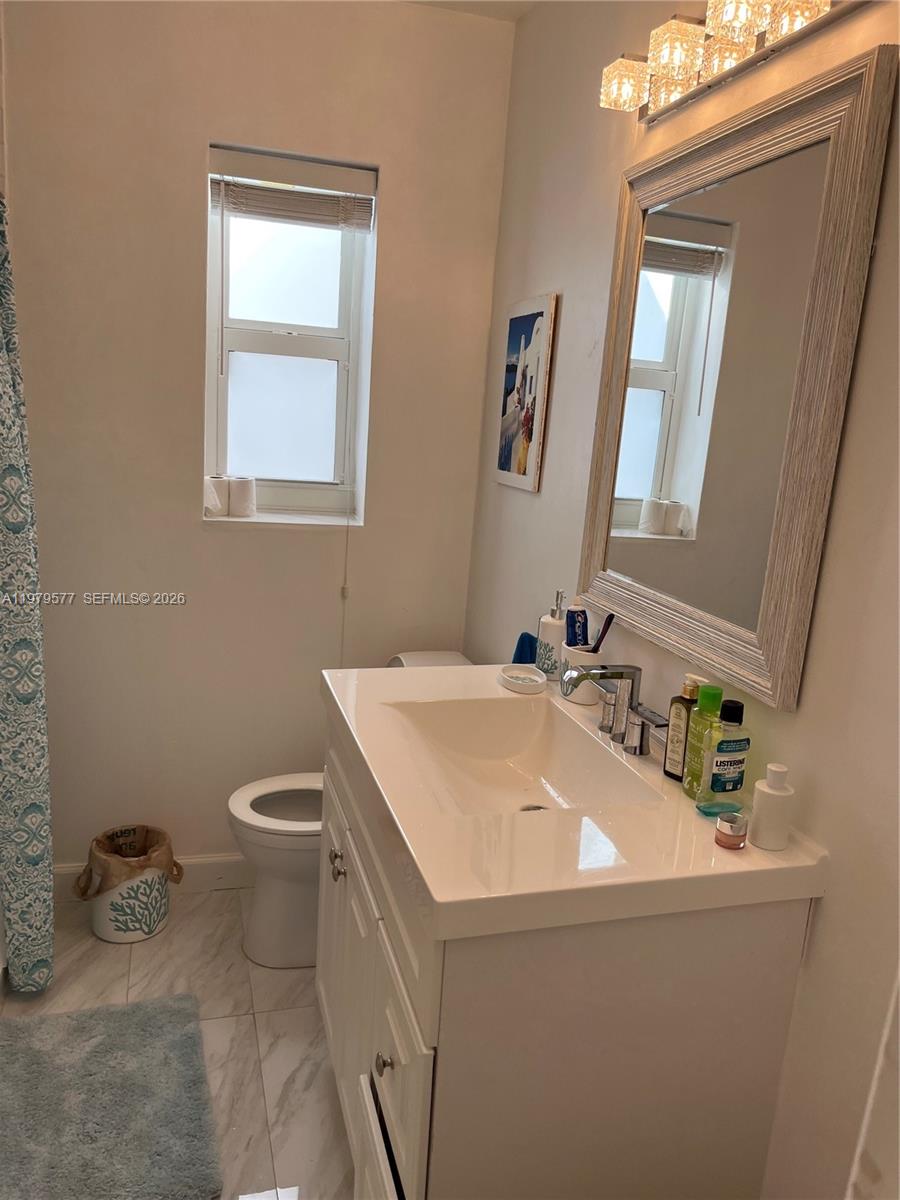 6910 Rue Notre Dame Miami Beach, FL 33141 - Photo 21 of 24 a bathroom with a sink toilet and mirror
