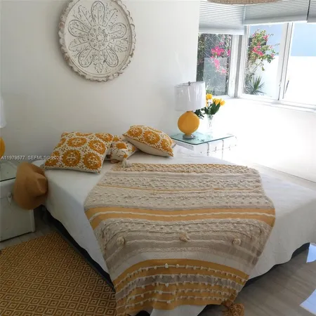a bedroom with a bed and painting on the wall