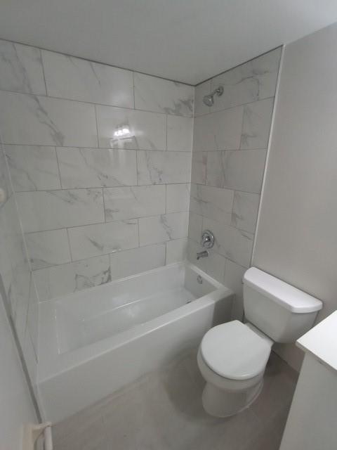 2641 Riverside Drive, Unit 5 Coral Springs, FL 33065 - Photo 11 of 27 a white toilet and tub sitting next to a bathroom sink