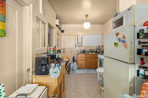 a kitchen with a refrigerator a stove and a dining table