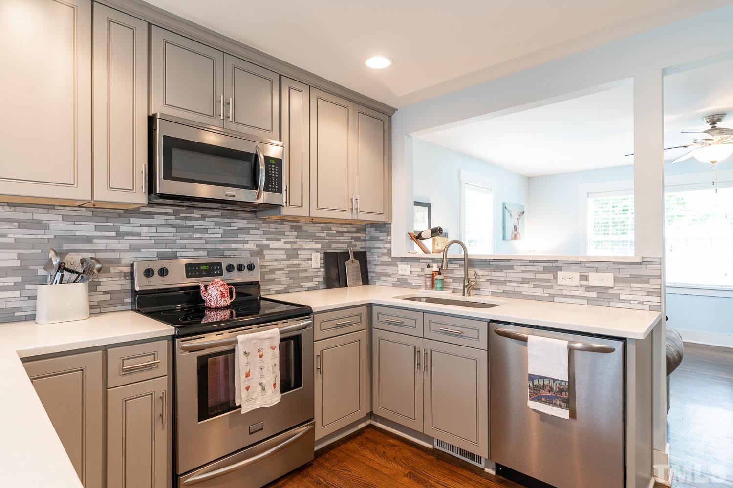 2513 Newbold Street Raleigh, NC 27603 - Photo 9 of 29 a kitchen with white cabinets sink and stainless steel appliances