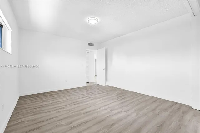 a view of an empty room with wooden floor