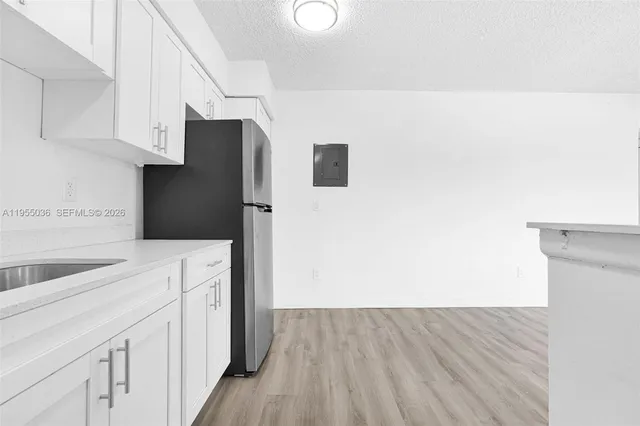a kitchen with cabinets and wooden floor