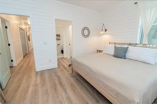 a bedroom with a bed and wooden floor