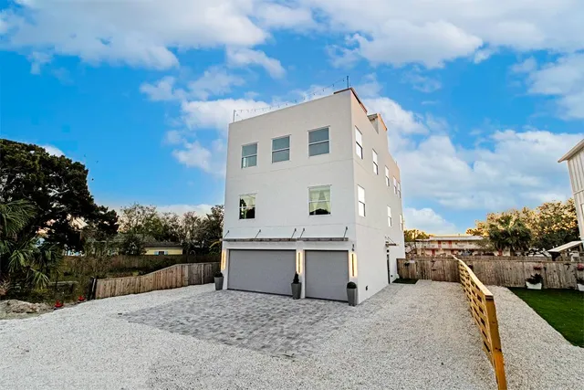 a kitchen with stainless steel appliances granite countertop a stove top oven a sink dishwasher and a dining table with wooden floor