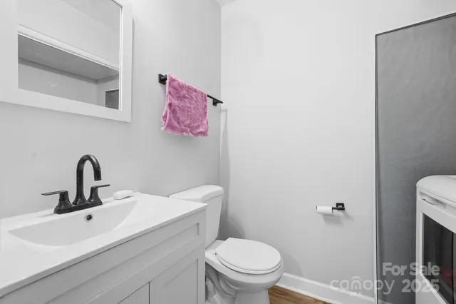 a bathroom with a sink mirror vanity and toilet