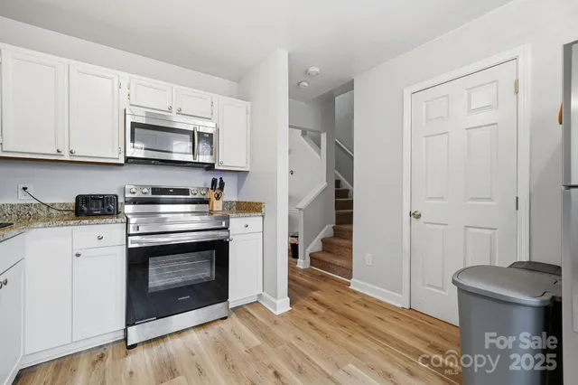 a kitchen with stainless steel appliances granite countertop a stove a microwave and a refrigerator