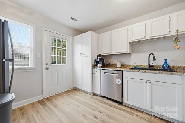 a kitchen with granite countertop white cabinets and white appliances