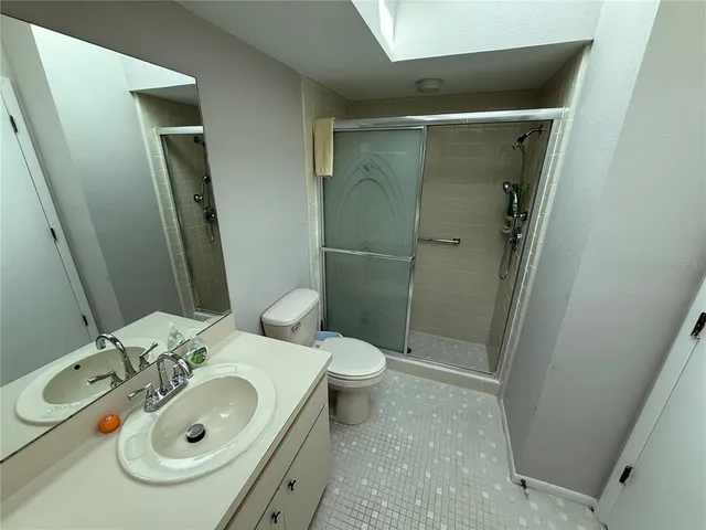 a bathroom with a sink and mirror with toilet