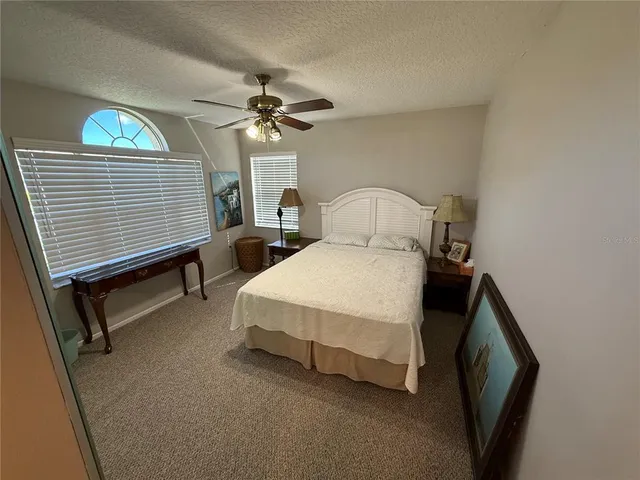 a spacious bedroom with a bed a chandelier and flat screen tv