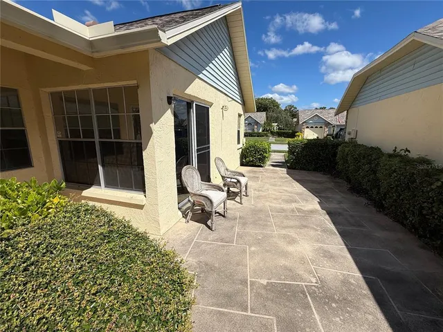 a view of a house with backyard and sitting area