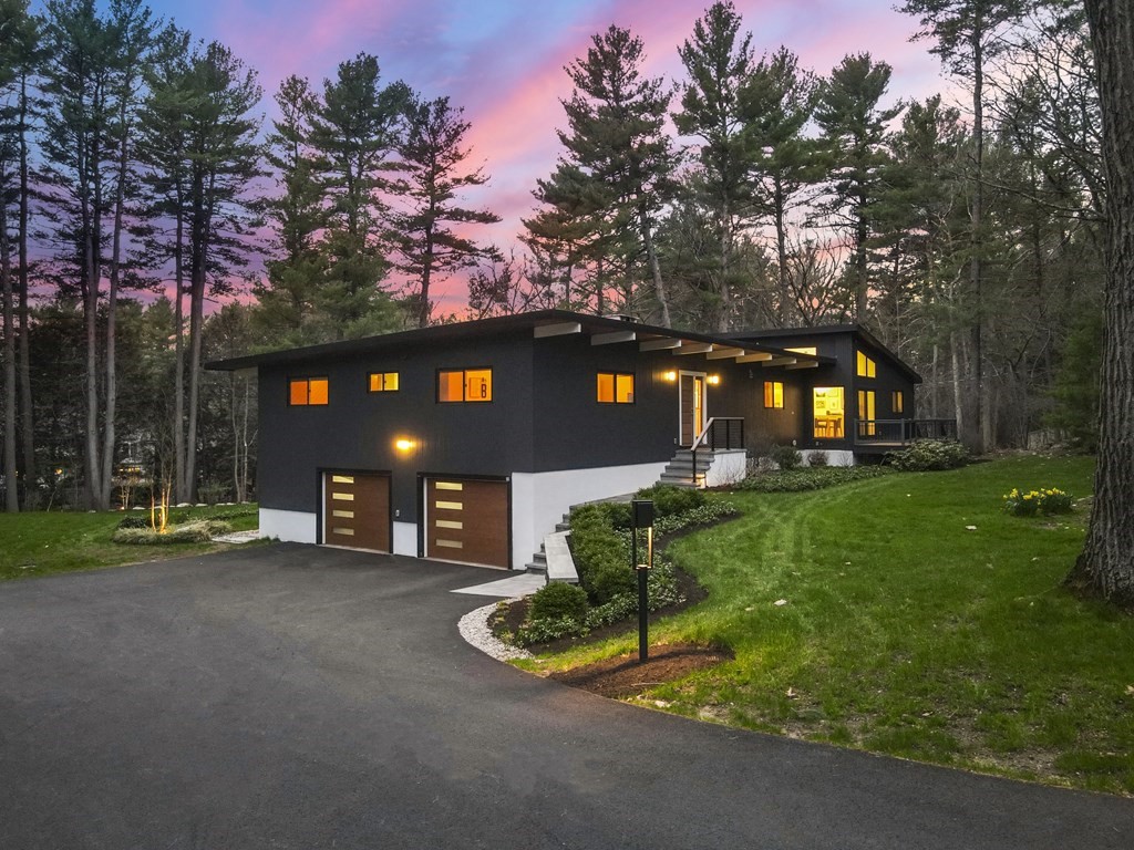 a front view of a house with a yard and tree s