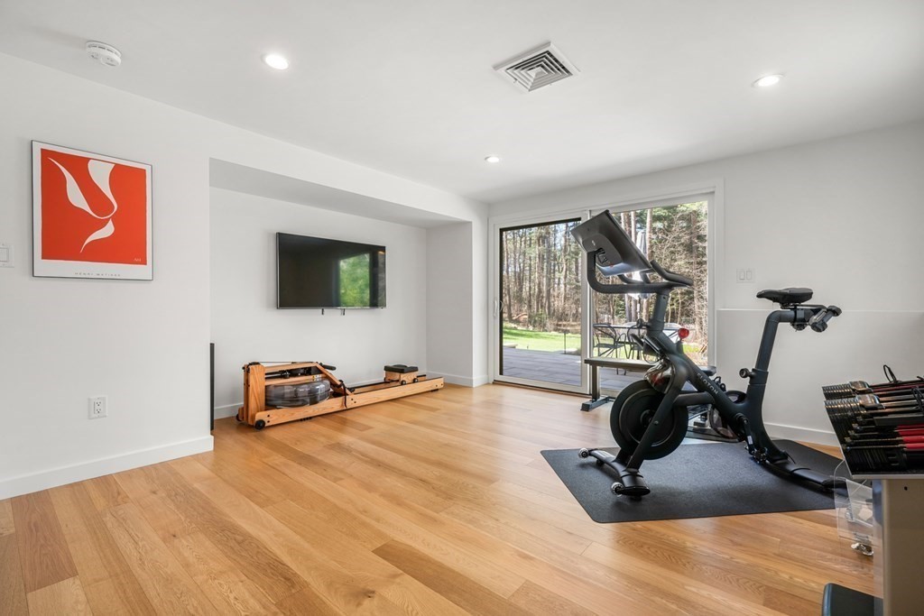 53 Beaver Road Weston, MA 02493 - Photo 30 of 38 a room with gym equipment and a flat screen tv