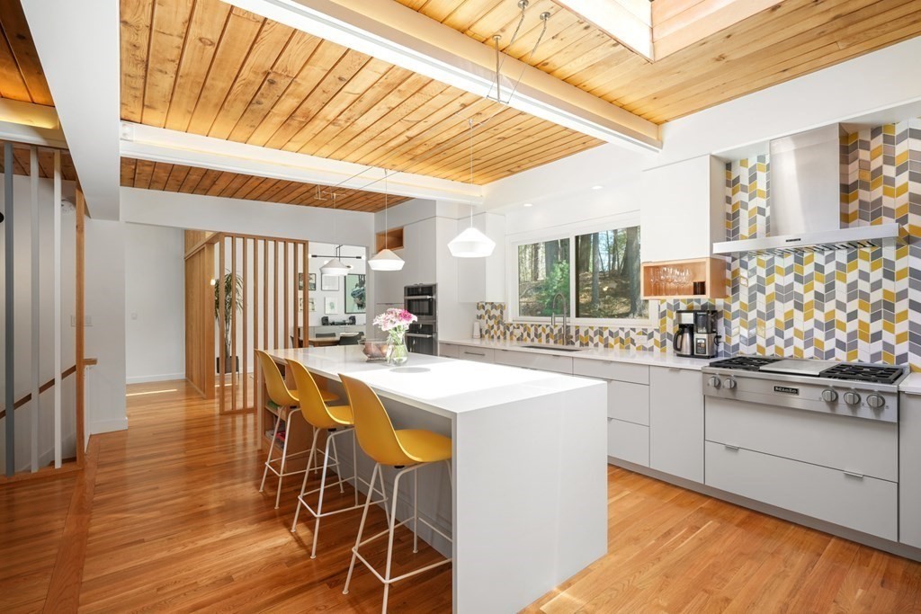 53 Beaver Road Weston, MA 02493 - Photo 4 of 38 a kitchen with stainless steel appliances granite countertop a stove and white cabinets with wooden floor