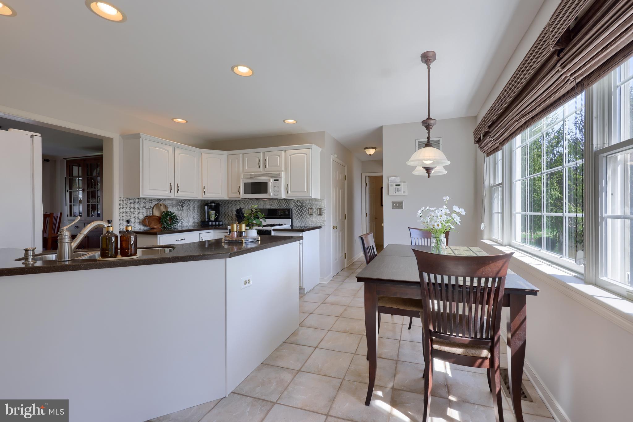 362 Squire Lane Lititz, PA 17543 - Photo 10 of 49 a kitchen with stainless steel appliances granite countertop a sink a stove a refrigerator cabinets dining table and a window